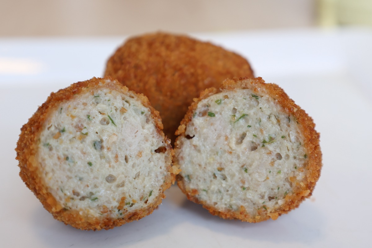Doorsnede van een crispy Surinaamse vleesworst met knapperige korst en sappige vulling